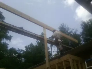 Carpenter setting a ridge beam over a new addition frame — Ice Dam Removal by Roofing Brothers in Hawthorne